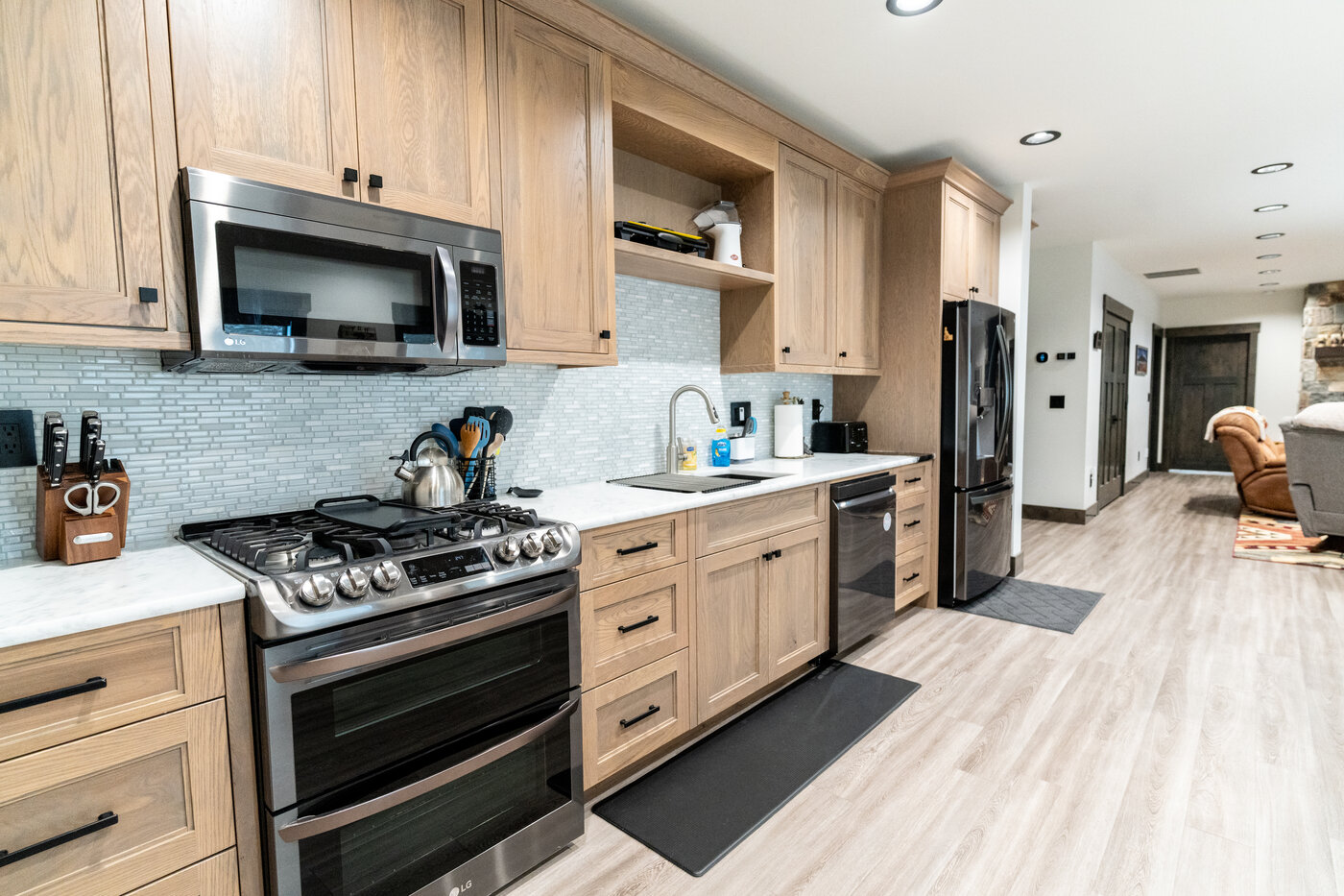 Beautiful Views — kitchen with gas range, stainless oven, and tile mosaic backsplash
