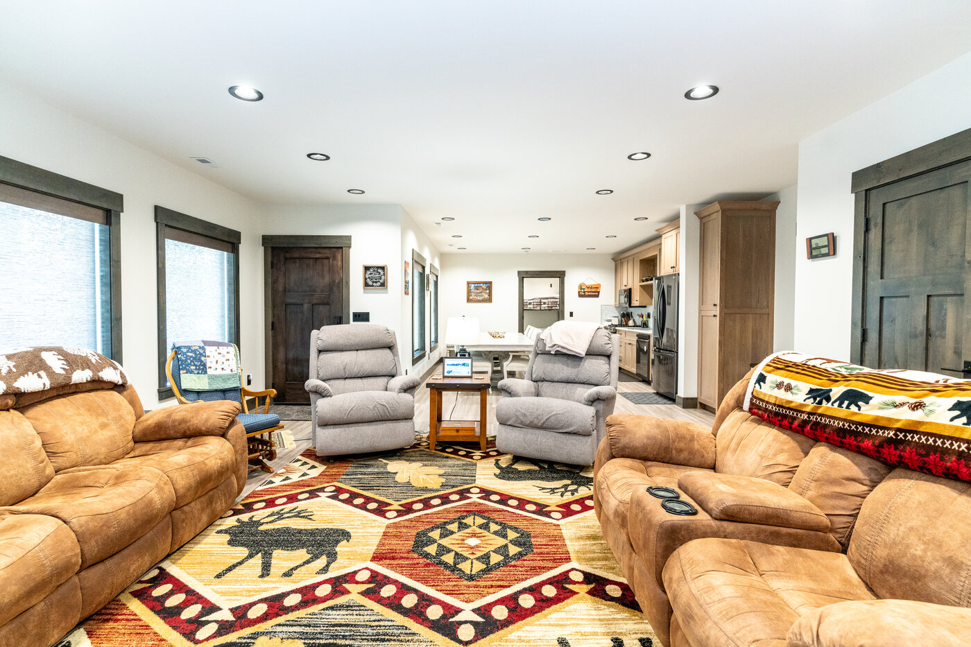 Beautiful Views — walkout living area with brown sectional, two recliners, and bear-print rug
