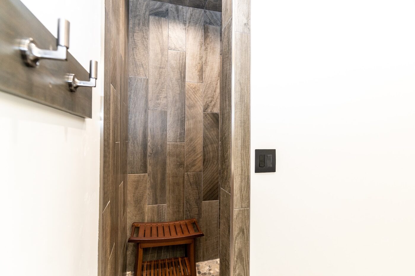 Beautiful Views — wood-grain tile shower with teak bench and corner shelves