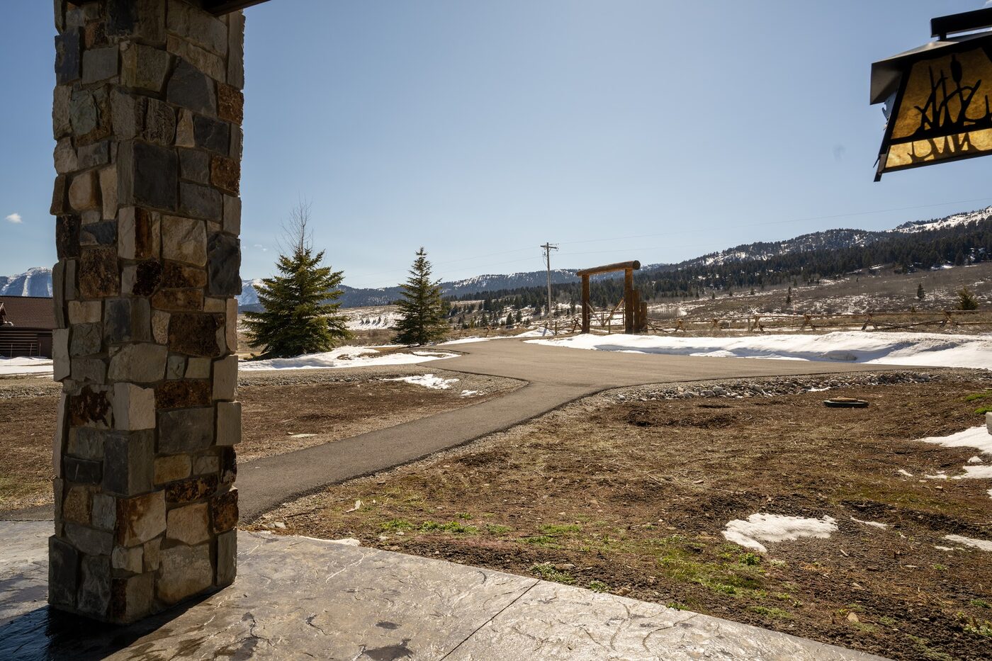 Beautiful Views — patio looking out from behind a stone pillar toward the lake and mountains