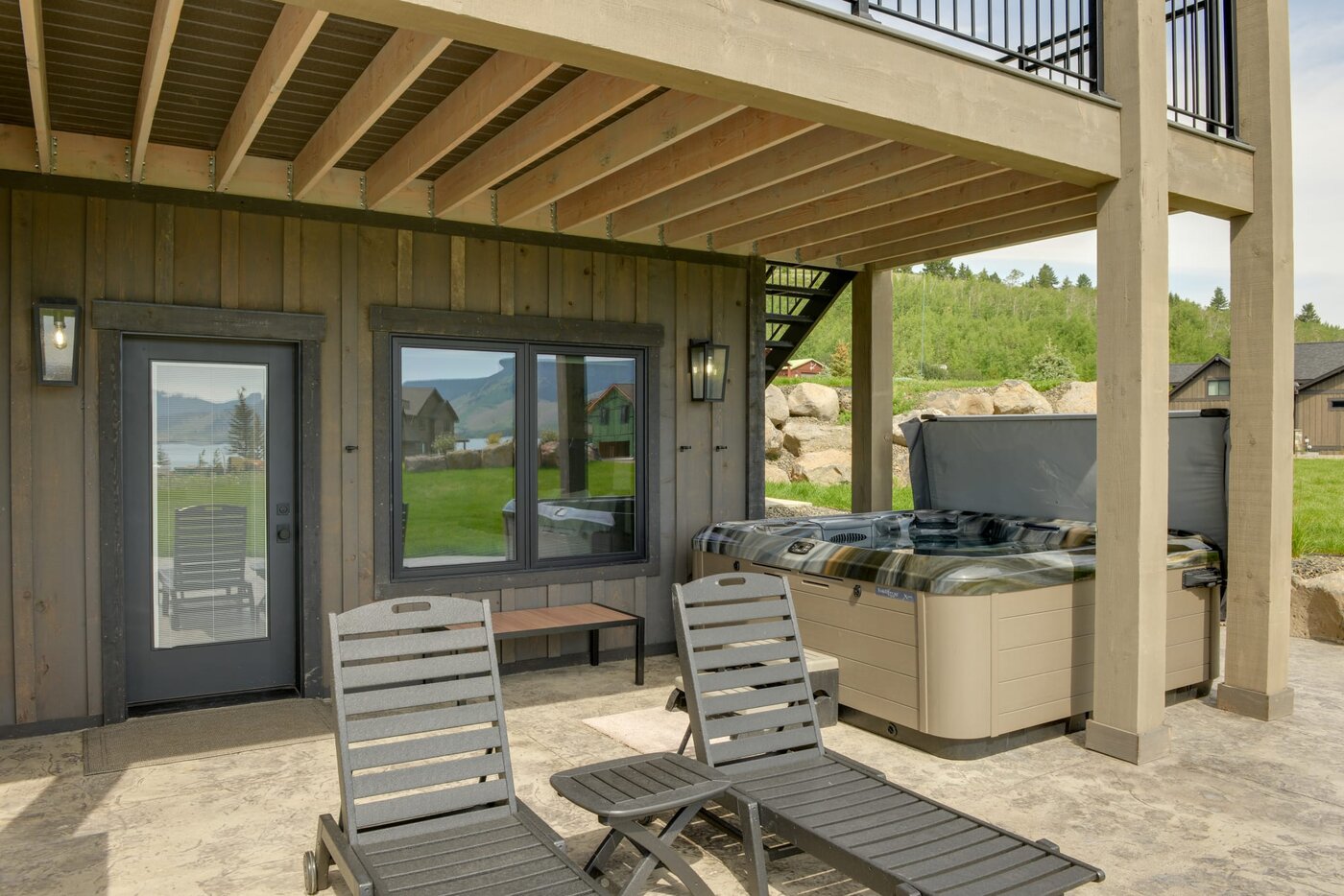 Lodge at Cutthroat Landing — hot tub on the lower patio with mountain views through the windows