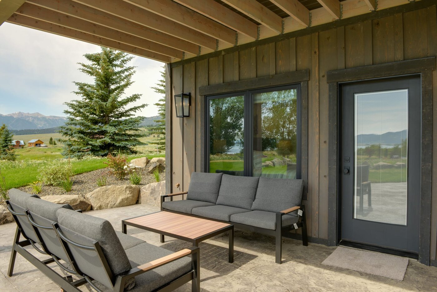 Lodge at Cutthroat Landing — covered outdoor lounge with cushioned seating and mountain views