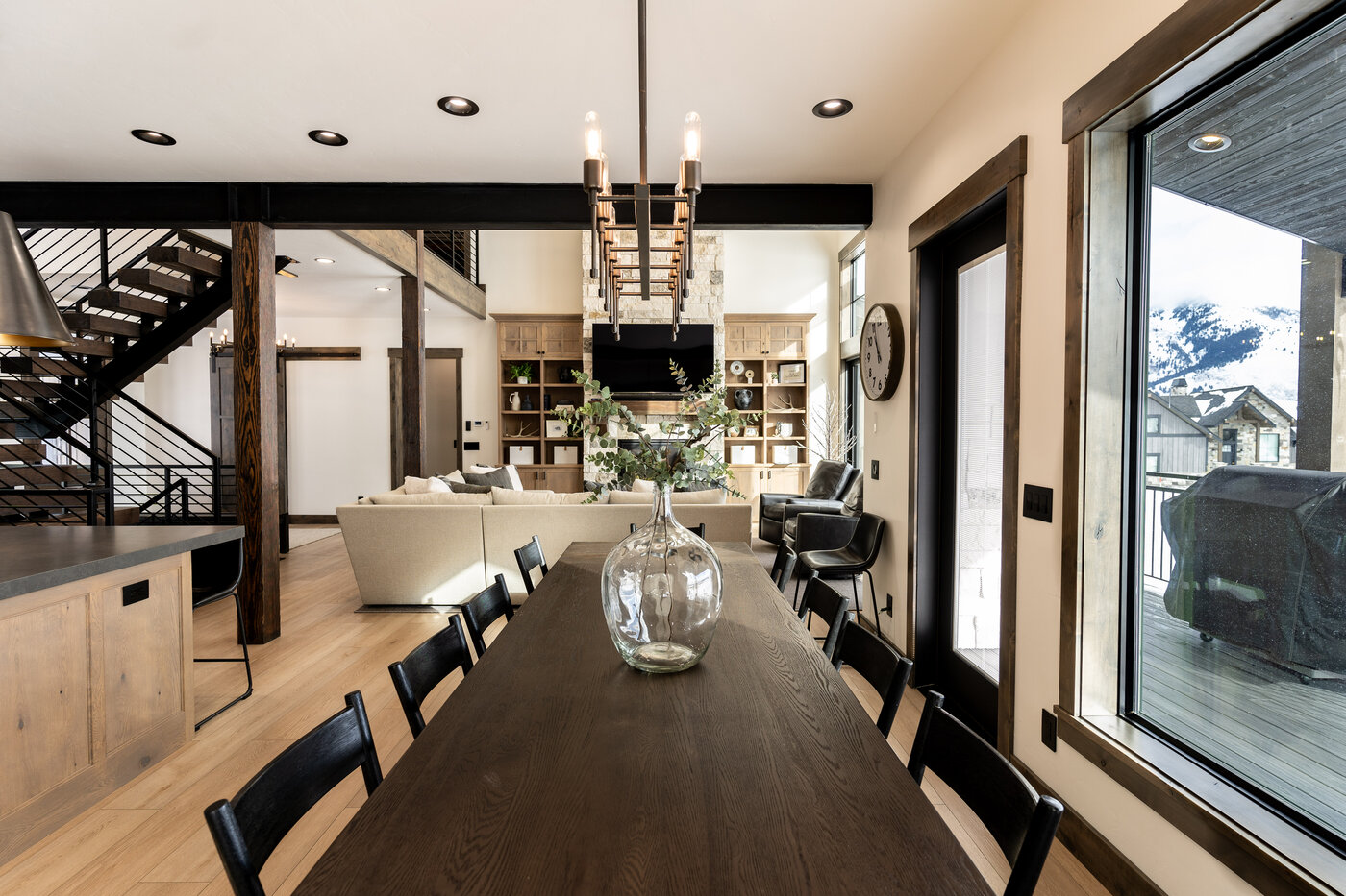 Lodge at Cutthroat Landing — long walnut dining table seating ten with chandelier and shelves behind