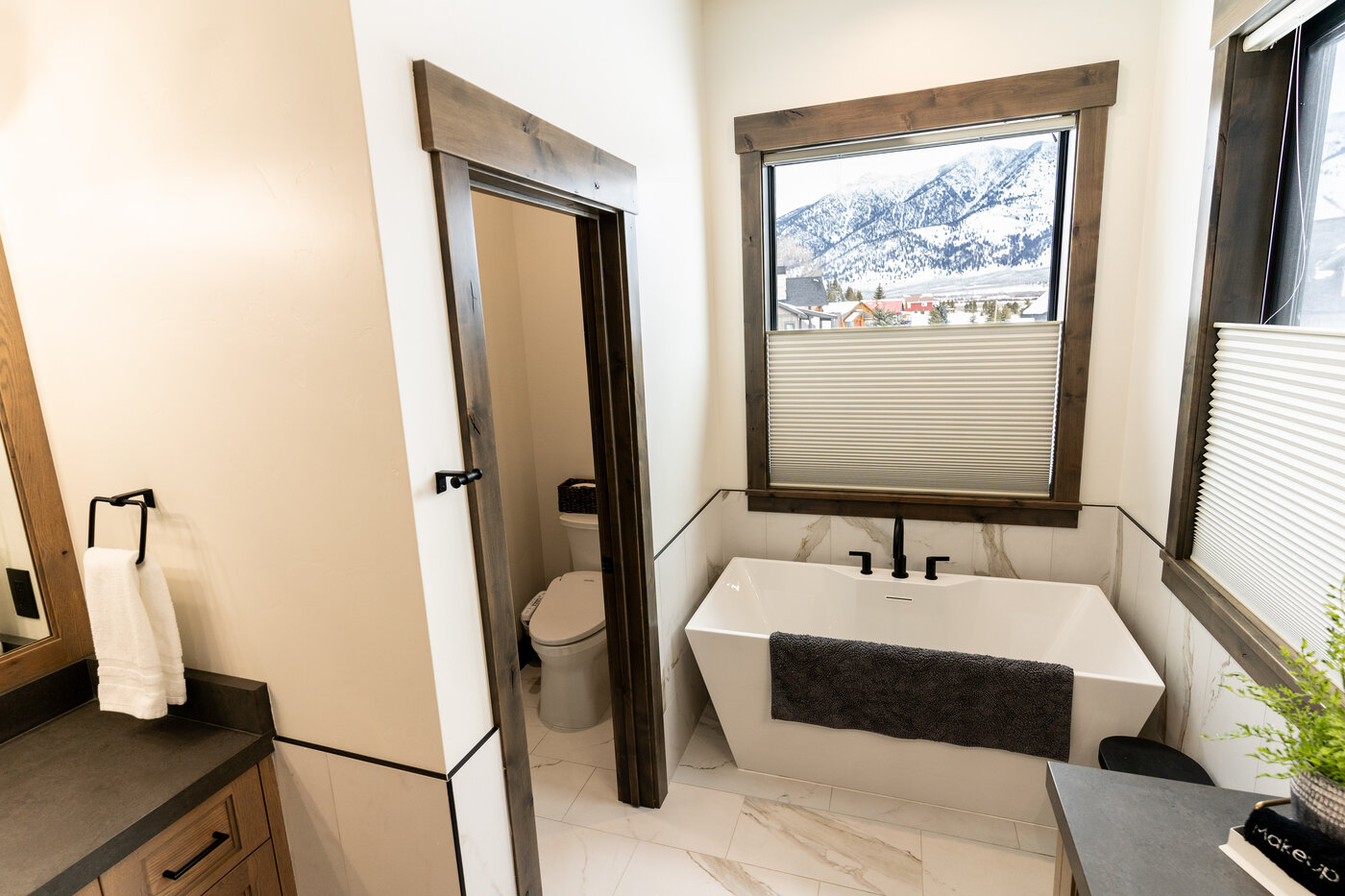 Lodge at Cutthroat Landing — primary bath soaking tub framed by a window with mountain view