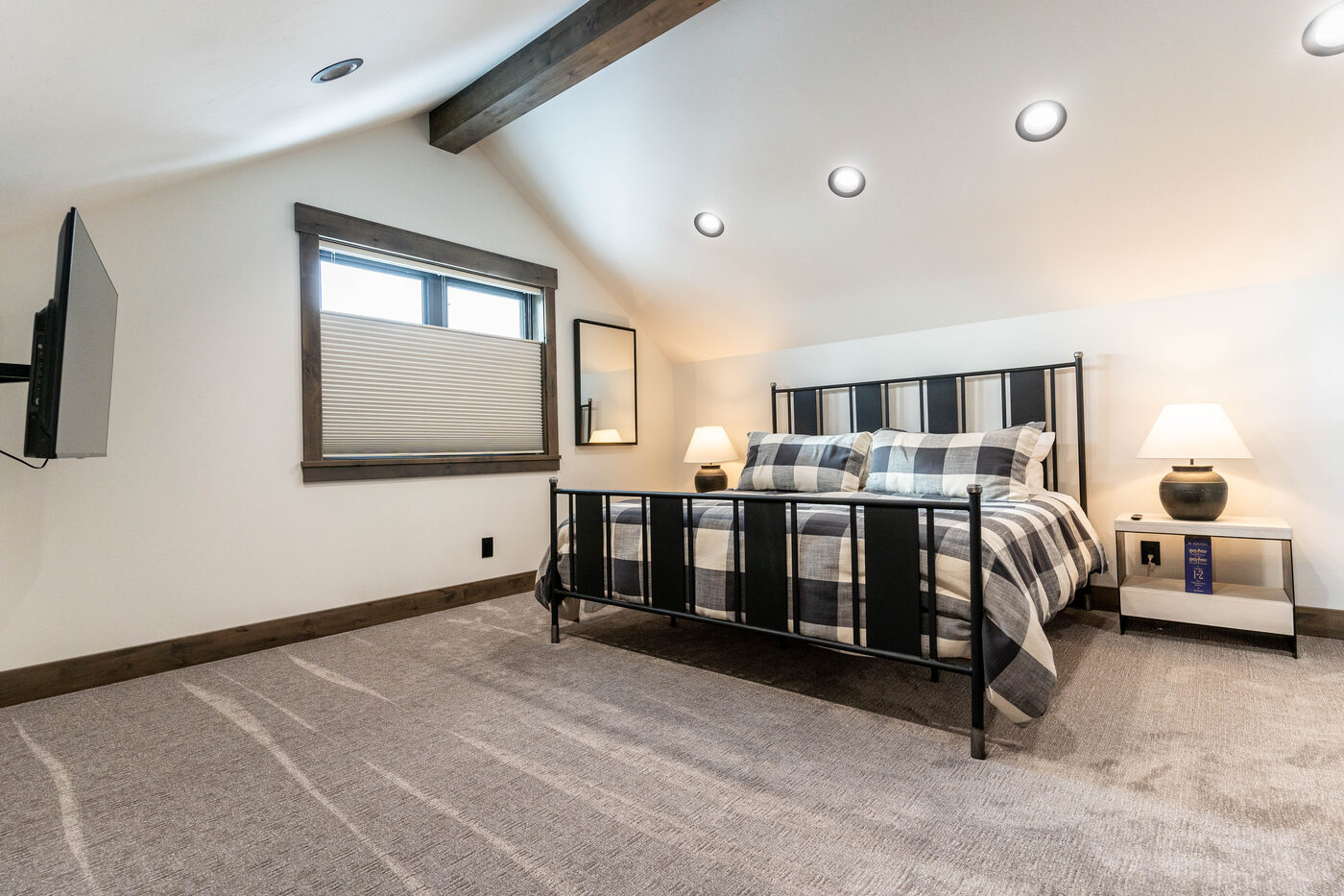 Lodge at Cutthroat Landing — loft king bedroom with iron-frame bed and vaulted ceiling