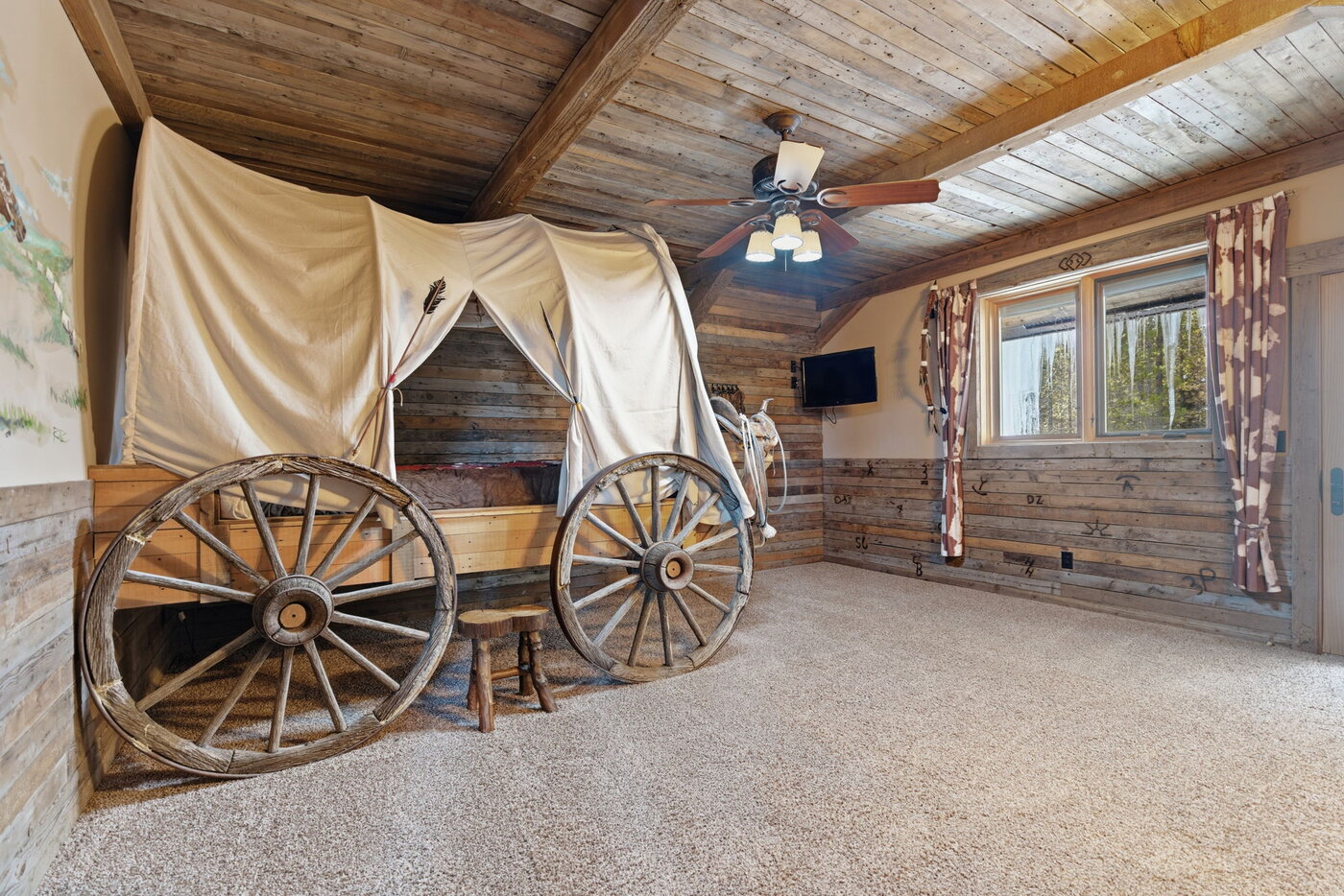 Riverfront Wildlife Lodge — kids bedroom with covered-wagon bed and antique wagon wheels
