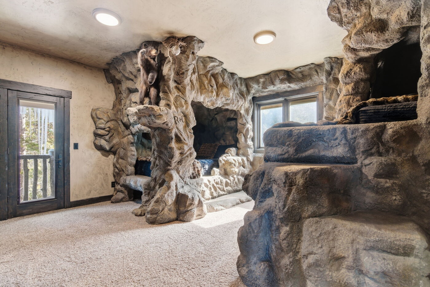 Riverfront Wildlife Lodge — bear-cave themed kids bedroom with sculpted rock walls and climbing bear
