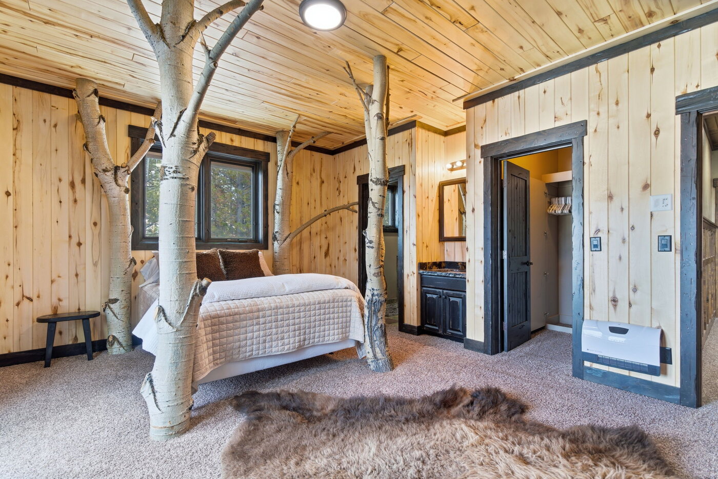 Riverfront Wildlife Lodge — bedroom with real aspen-tree posts framing the bed