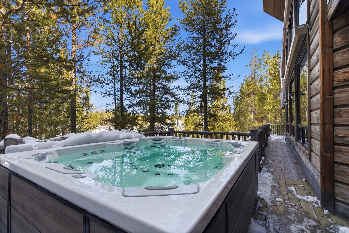 Riverfront Wildlife Lodge — hot tub in snow with surrounding lodgepole pines