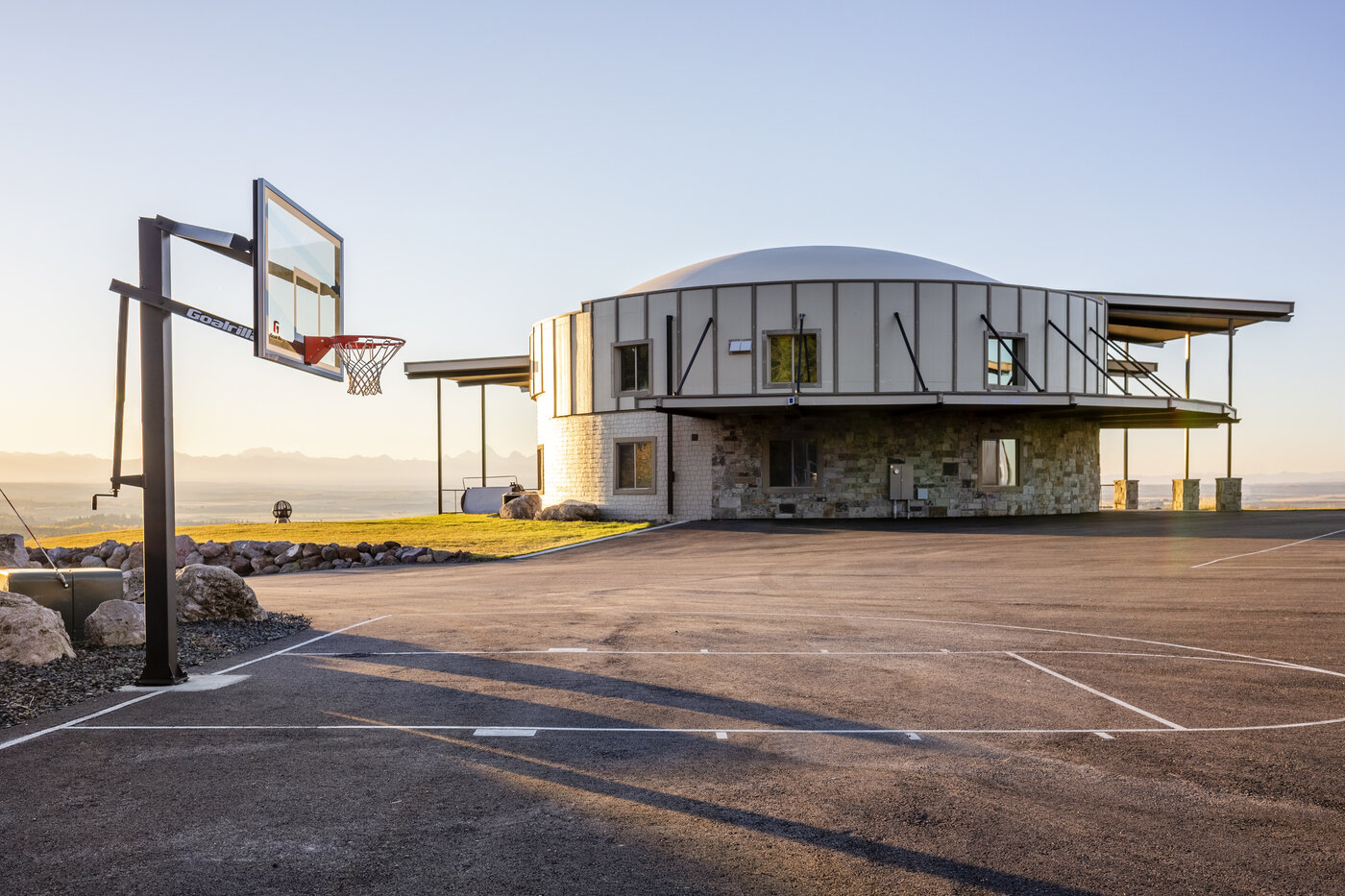 Teton View Retreat — Both Domes — dome cabin exterior with basketball court out front