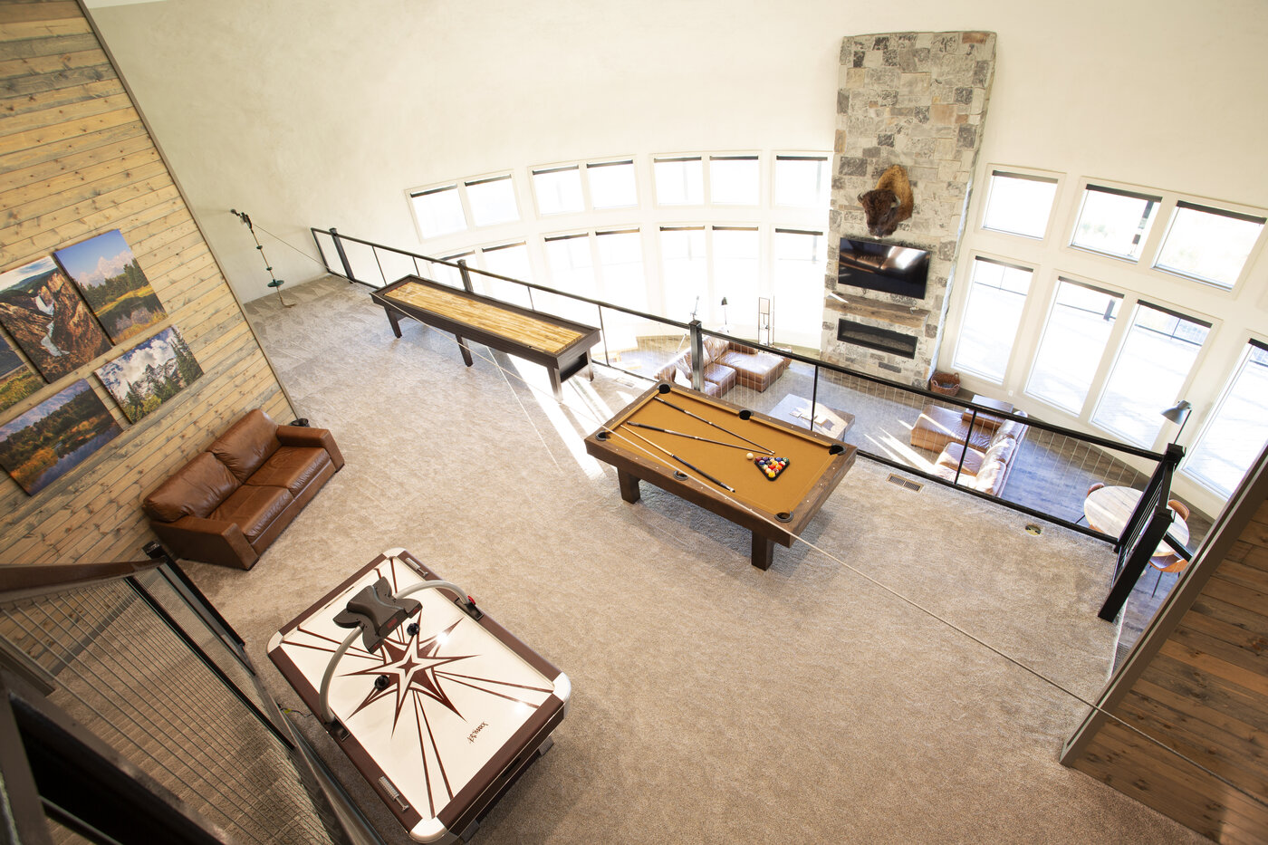 Teton View Retreat — Both Domes — game room looking down from the upper floor showing pool table and stone fireplace