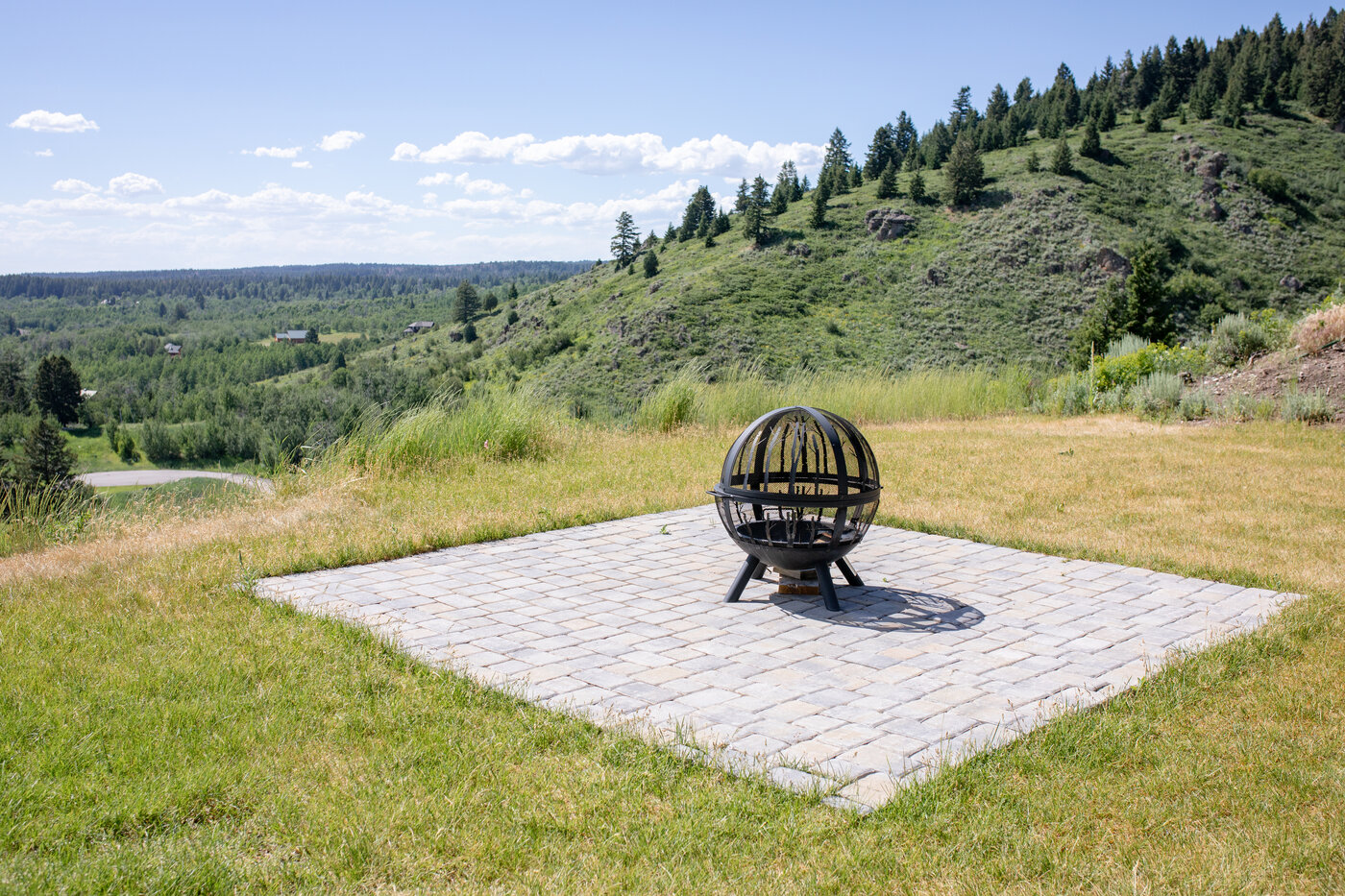 Teton View Retreat — Both Domes — sphere fire pit on a paver patio overlooking the valley