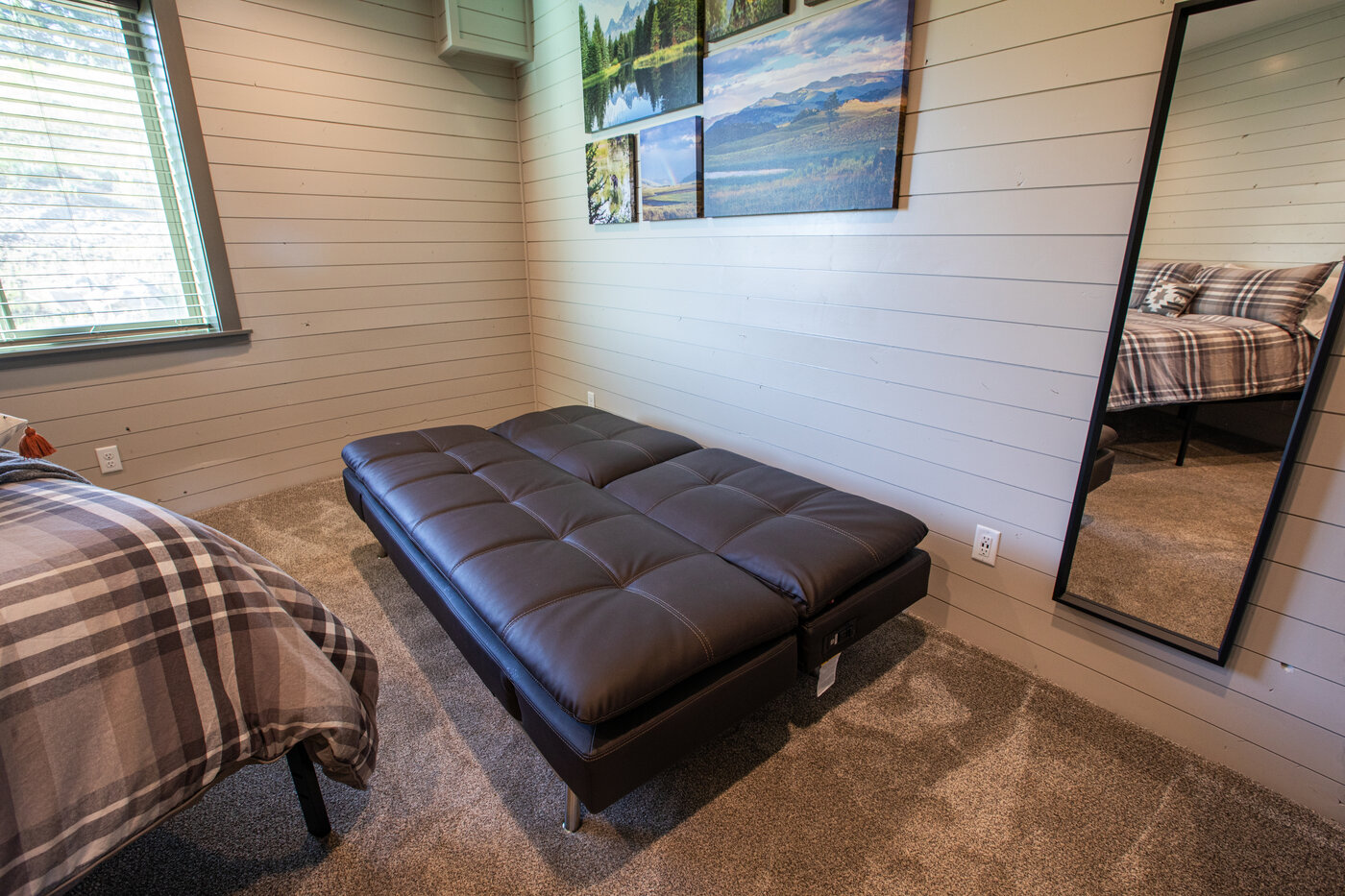 Teton View Retreat — Both Domes — bedroom with chocolate futon, plaid bedding, and framed nature photography