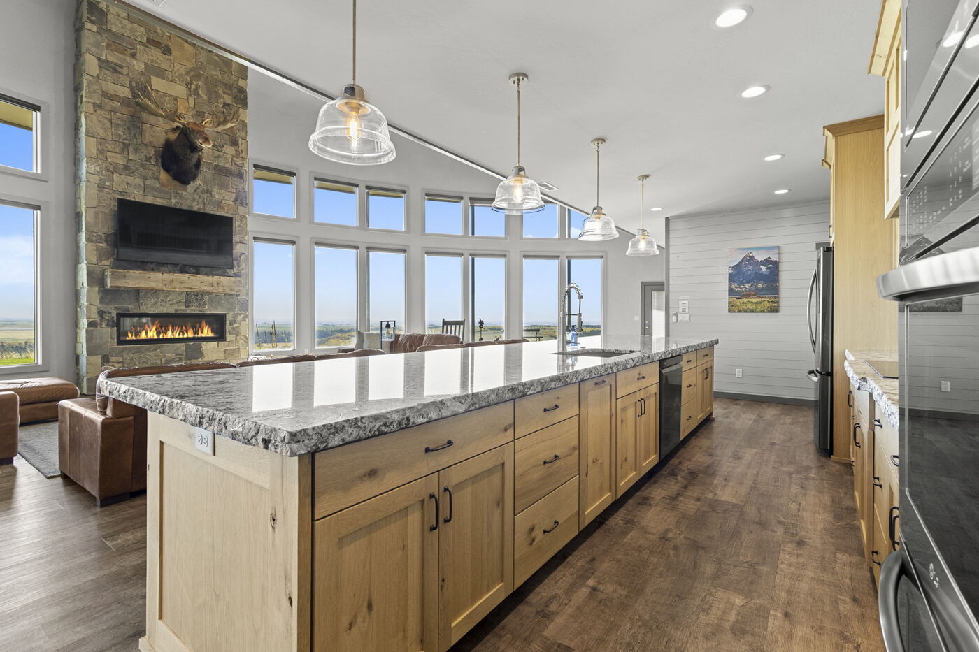 Teton View Retreat — Both Domes — kitchen with long granite island, pendant lights, and Tetons through the windows