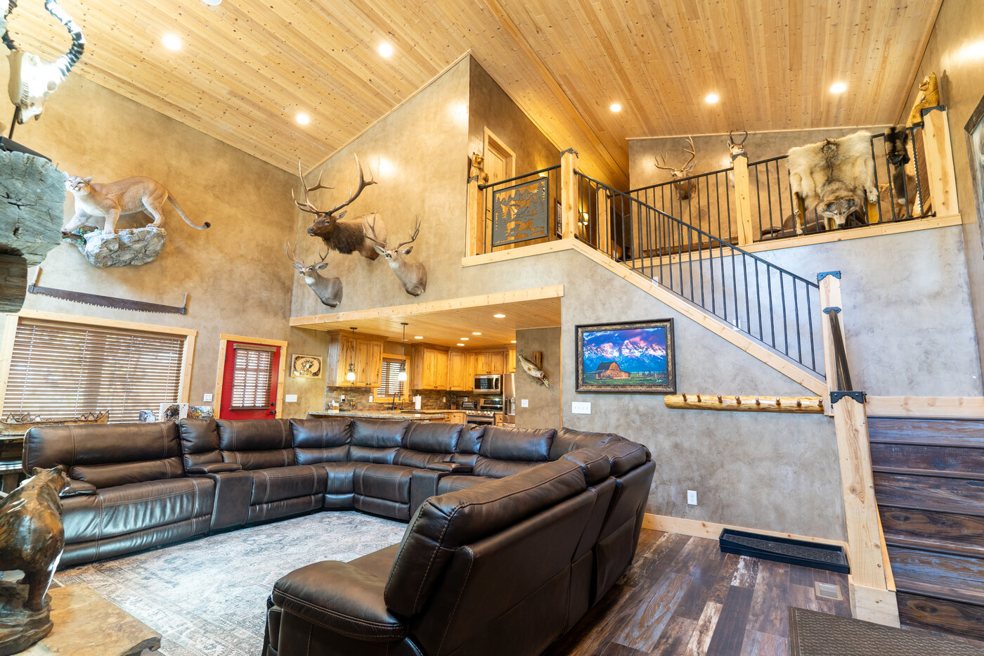 Trails End Lodge — full great room with leather sectional, sweeping cathedral, and taxidermy on every wall