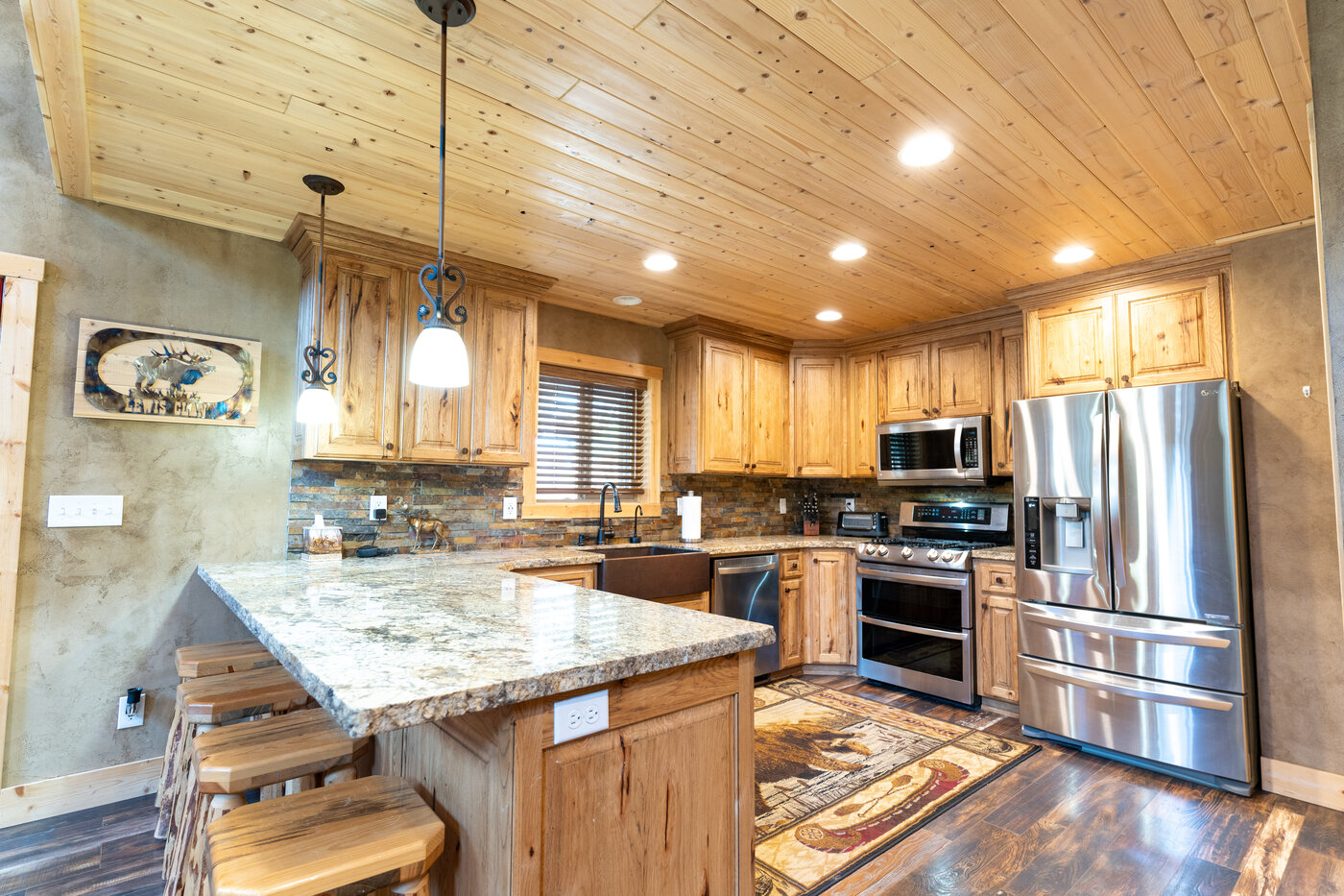 Trails End Lodge — kitchen with hickory cabinets, hammered-copper sink, and rustic light fixtures