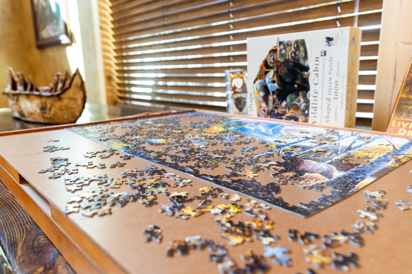 Trails End Lodge — wildlife cabin jigsaw puzzle laid out on a table with the box behind it