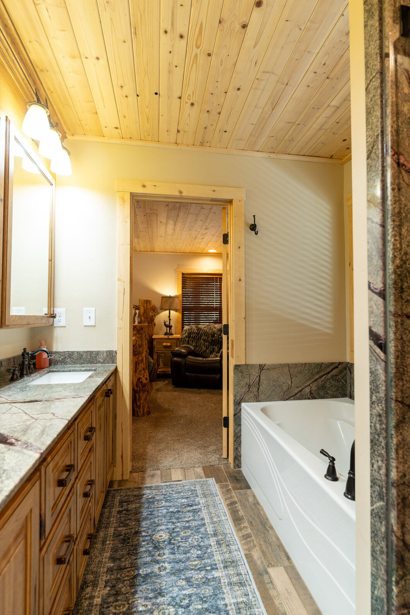 Trails End Lodge — bathroom with granite vanity and built-in soaker tub looking into bedroom