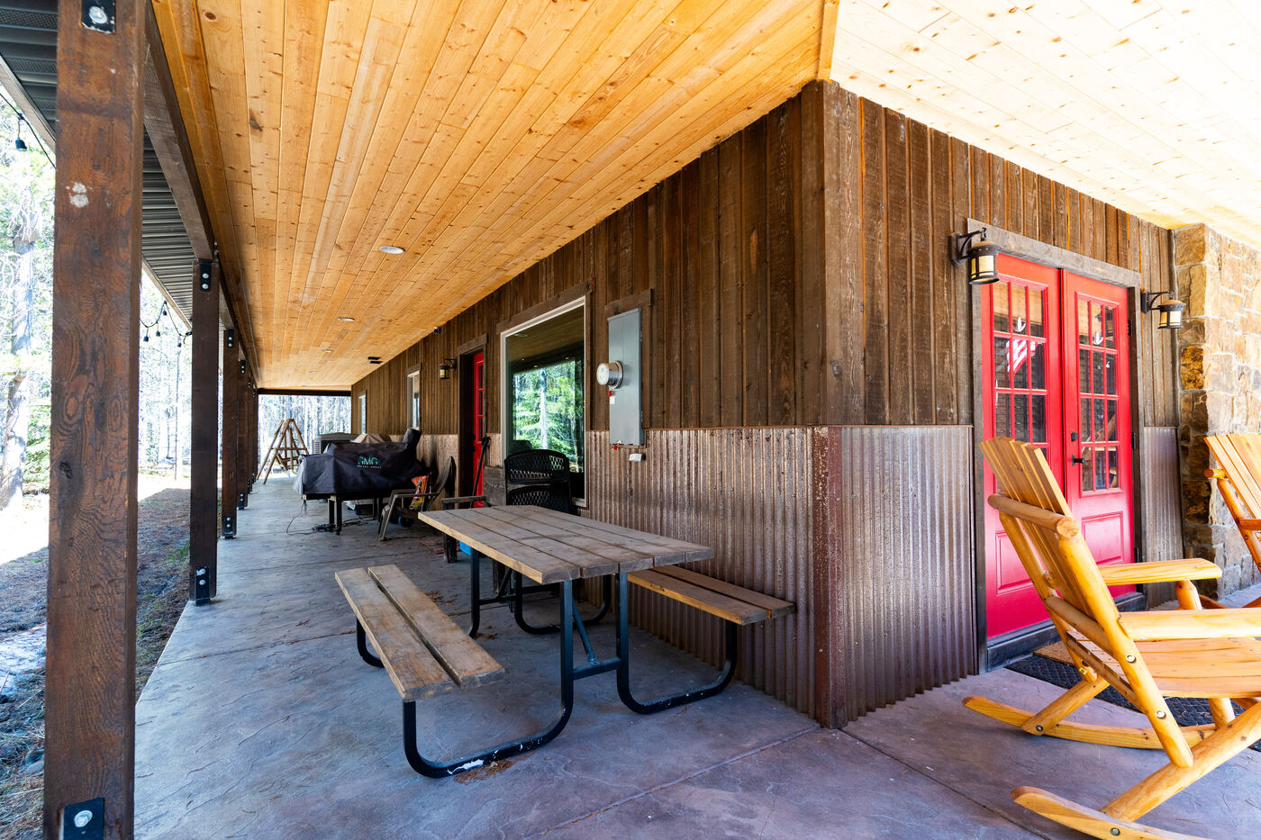 Trails End Lodge — wraparound porch with picnic tables, grills, and corrugated wainscot