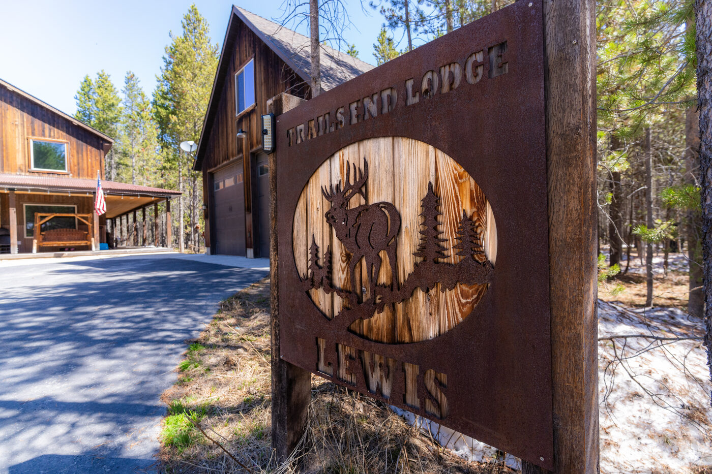 Trails End Lodge — entry sign with elk silhouette and lodge name carved in steel