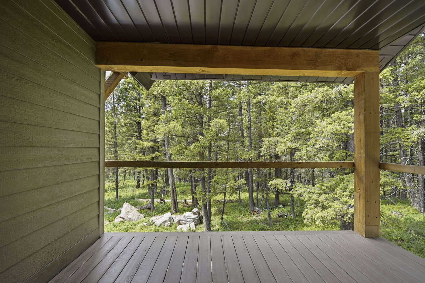 The Treehouse — covered deck looking into the surrounding pine forest