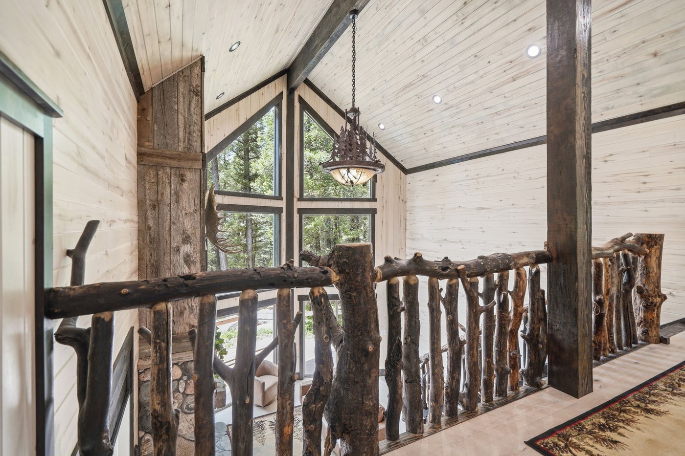 The Treehouse — loft landing with branch railing overlooking the great room
