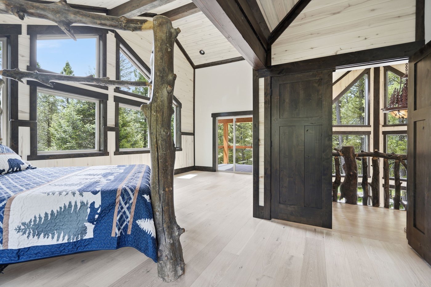 The Treehouse — bedroom with tree post bed and private deck access